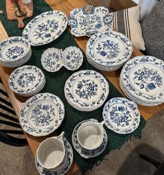 a table topped with lots of blue and white plates