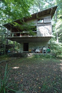 a house in the woods with people sitting outside