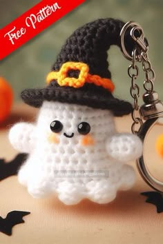 a crocheted keychain with a small white ghost wearing a witches hat