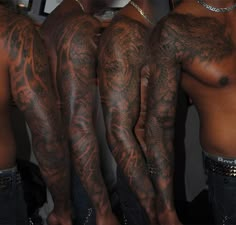 three men with tattoos on their arms and legs, one is showing off his arm