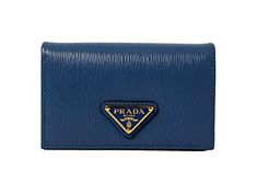 This vibrant blue Prada card holder is an effortlessly chic way to store credit cards, business cards, coins, and small objects. The wallet's conveniently small size makes it easy to keep in your purse or pocket. Three card slots and a main pocket mean organizing is a breeze.     Model: 1MC122  Cobalto blue leather  Gold-tone hardware  Snap closure  Card holder/wallet  Signature Prada Triangle logo   Measurements: 4.5" x 1.5" x 2.5" (LWH)  Includes authenticity cards and Prada box   Made in Ital Modern Wallets With Logo Plaque For Everyday, Luxury Blue Leather Card Holder, Designer Blue Card Holder For Everyday, Classic Blue Wallets With Card Slots, Classic Blue Wallet With Card Slots, Luxury Blue Wallet With Rfid Blocking, Designer Blue Bifold Wallets, Luxury Blue Card Holder As Gift, Luxury Blue Card Holder For Gift