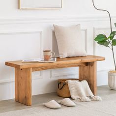 a wooden bench sitting next to a potted plant on top of a white rug