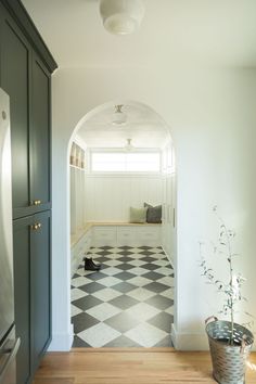 an archway leads into a kitchen with checkered flooring