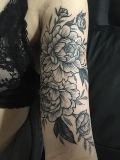 a woman's arm with black and white flowers on it