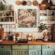 a kitchen with green cabinets and pink flamingos on the wall