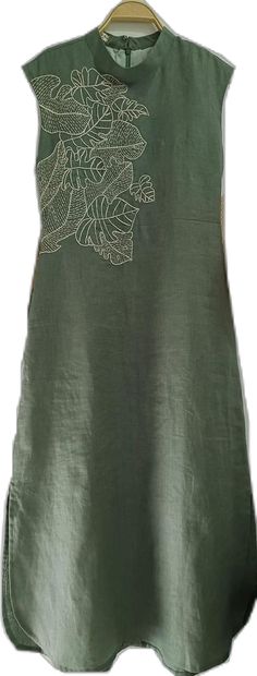 a green top with an embroidered design on it