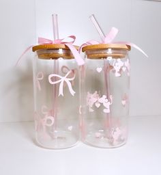 two glass jars with pink bows and wooden lids