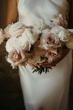 a woman in a white dress holding a bouquet of flowers