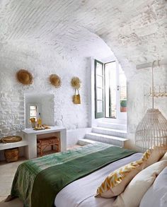 a bedroom with white walls and green bedspread