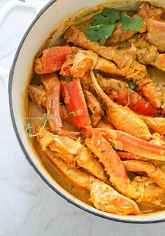 cooked crabs in a pot with herbs and spices on the side, ready to be eaten