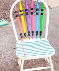 a white chair with colorful crayons sitting on it's back and legs