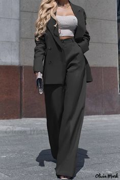 a woman is walking down the street wearing a black suit