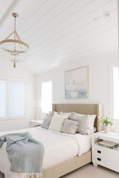 a bedroom with a bed, dresser and chandelier hanging from it's ceiling