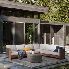 a large sectional couch sitting on top of a wooden floor next to a patio area