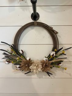 a wreath hanging on the wall with dried flowers