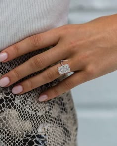 a woman's hand wearing a diamond ring