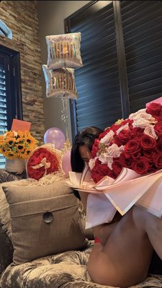 a woman sitting on top of a couch holding a bouquet of roses