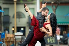 a man and woman dancing on the street