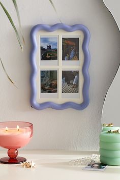 a white table topped with a pink bowl next to a mirror and vase filled with flowers