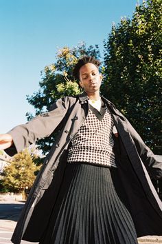 a woman in a black and white top is holding her arms out