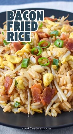 bacon fried rice on a black plate with green onions