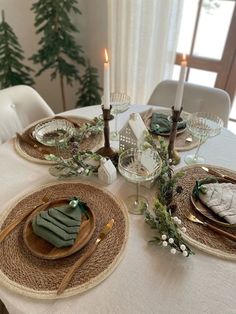 the table is set with plates, napkins and silverware for christmas dinner guests to enjoy