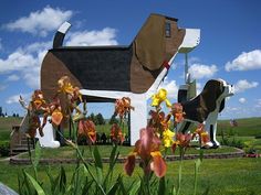 a statue of a dog with flowers in front of it