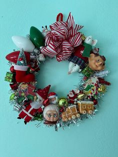 a christmas wreath is hanging on the wall with ornaments and decorations around it, including santa's sleigh ornament