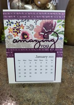 a calendar card with an image of flowers on it and the word, amazing you