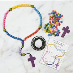 a cross, bracelet and beads on a marble surface with a note that says how to make a bead necklace