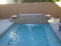 an outdoor hot tub in the middle of a patio with two bowls on each side