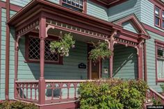 a blue house with red trim and green siding