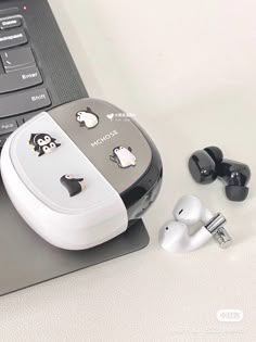 an open laptop computer sitting on top of a table next to ear buds and headphones