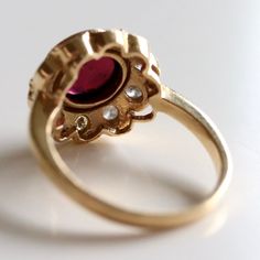 This dramatic ring demand an evening on the town. 0.67 carats of hand faceted diamonds are paired with an oversized cabochon garnet and set in 14k gold.Ring size ranges from 5-8. Timeless Diamond Rings With Cabochon, Formal Garnet Ring With Center Stone, Elegant Oval Ruby Ring With Rose Cut Diamonds, Elegant Ruby Ring With Bezel Setting, Elegant Ruby Ring With Oval Diamond, Elegant Garnet Ring With Center Stone, Elegant Oval Cabochon Ruby Ring For Wedding, Oval Cabochon Ruby And Diamond Ring, Elegant Ruby Cluster Ring With Rose Cut Diamonds