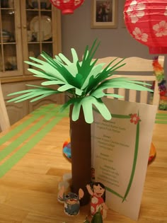 a paper palm tree sitting on top of a wooden table