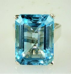 ALL OUR JEWELRY IS MADE IN THE U.S.A. Clear, blue skies on the sunniest of days THIS is the blue of this wonderful Blue Topaz, set in a wide band solitaire design. this a large Topaz but not too large, this ring is for the PRINCESS in you... or your daughter, or your wife, or mom. Whomever is the lucky girl, she will LOVE, LOVE, LOVE this ring, and so will everyone who sees her wearing it! Setting is made of solid .925 sterling silver. BEAUTIFUL Blue Topaz, (1) 16X12 Emerald cut, 13.50 Carats Classic Light Blue Topaz Gemstone Ring, Blue Emerald Cut Solitaire Topaz Ring, Octagonal Blue Topaz Ring With Prong Setting, Formal Octagon Topaz Ring In Sterling Silver, Octagonal Topaz Ring For Anniversary, Silver Octagon Blue Topaz Ring, Octagon Shaped Silver Topaz Ring, Sterling Silver Topaz Ring With Rectangular Stone For Formal, Formal Sterling Silver Topaz Ring With Rectangular Stone