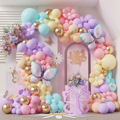 the balloon arch is decorated with pastel colors and gold accents for a fairy birthday party