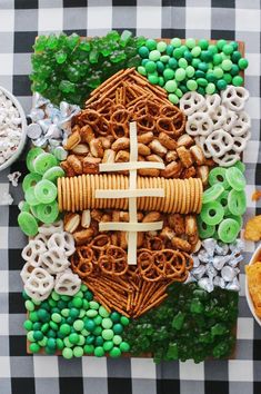 a cross made out of pretzels and cereals on a checkered tablecloth