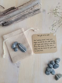 some rocks are sitting on a table next to a bag with a poem written in it