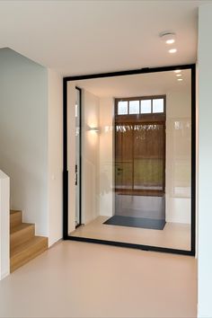 an empty room with stairs and a glass door