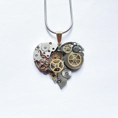 I disassemble two new intricate watch movements and recreate them into a heart-shaped mechanical pendant showcasing a striking steampunk mechanical aesthetic. With its detailed gears and vintage charm, it resembles a "mechanical heart" in motion, embodying individuality and strength. Its unique design highlights the beauty of mechanical craftsmanship, making it a true standout piece. Whether as a bold statement accessory or a meaningful gift for someone special, this creation leaves a lasting impression. Let this mechanical heart become your signature symbol or a heartfelt surprise for a loved one! INTERNATIONAL CUSTOMERS Please research your country's customs regulations before purchasing. We are not responsible for any additional charges/fees that may occur during shipment through custom Mechanical Aesthetic, Mechanical Heart, Pendant Necklace Vintage, Heart Shaped Pendant Necklace, Unique Jewelry Gifts, Golden Heart, Watch Parts, Industrial Art, Heart Gifts