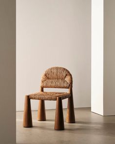 a chair made out of wood and wicker sitting in front of a white wall