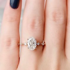 a close up of a person's hand with a diamond ring on their finger