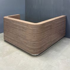 a large wooden box sitting on top of a tile floor next to a blue wall