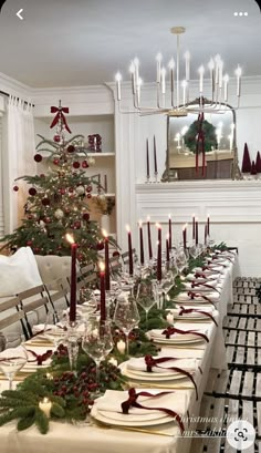 a dining room table set for christmas dinner with candles and decorations on the long table