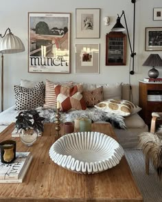 a living room filled with lots of furniture and pictures on the wall above it's coffee table