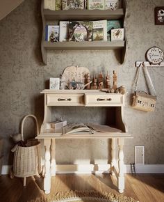 a room with a desk and shelves filled with books on top of the wall next to a rug