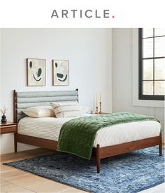 a bed sitting on top of a blue rug next to a wooden headboard and foot board