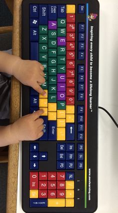 a child is typing on a colorful keyboard