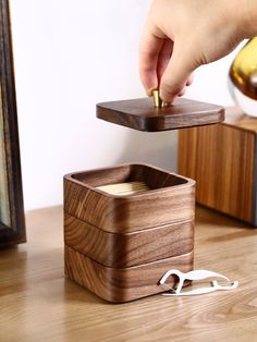 a wooden box with a pair of scissors in it sitting on top of a table